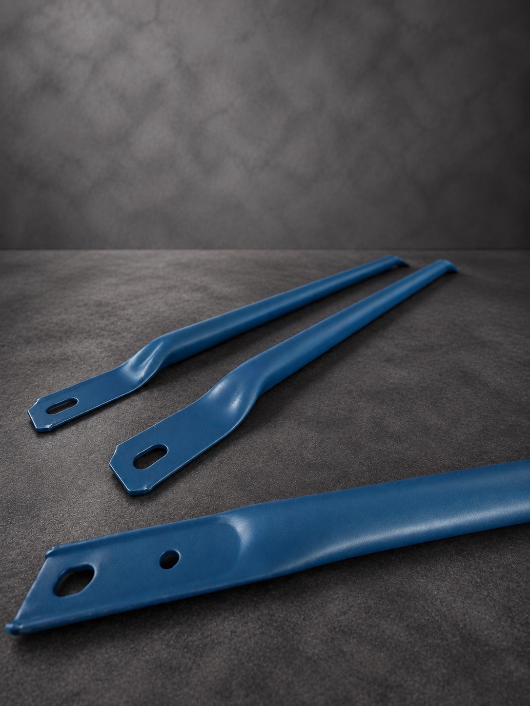 Close-up of blue Cerakote H Series brackets showing mounting holes and formed edges