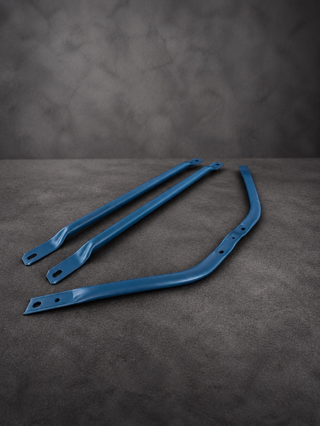 Three blue Cerakote H Series brackets arranged on a textured grey surface