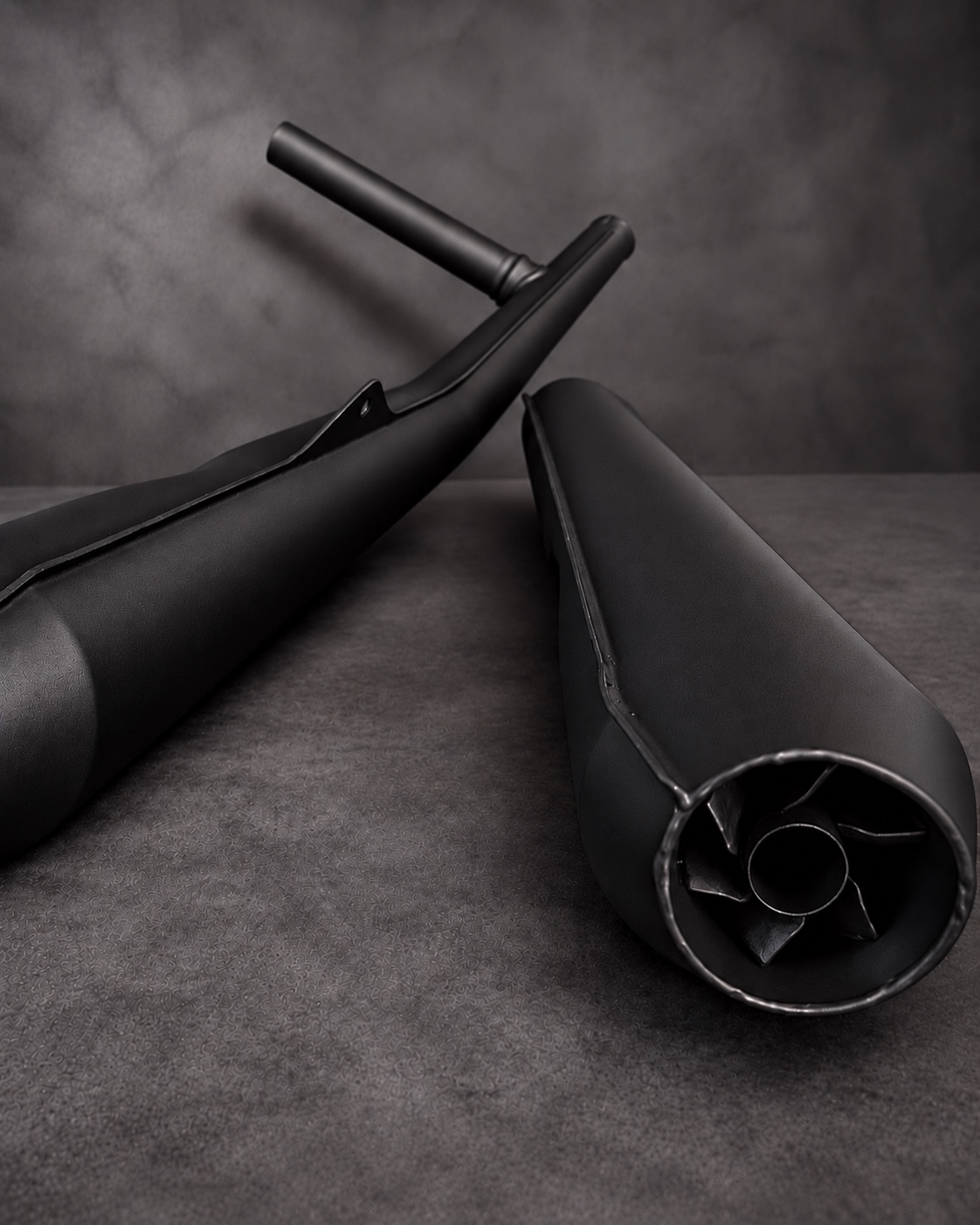 Black Cerakote V Series motorcycle silencers showing the outlet and surface finish