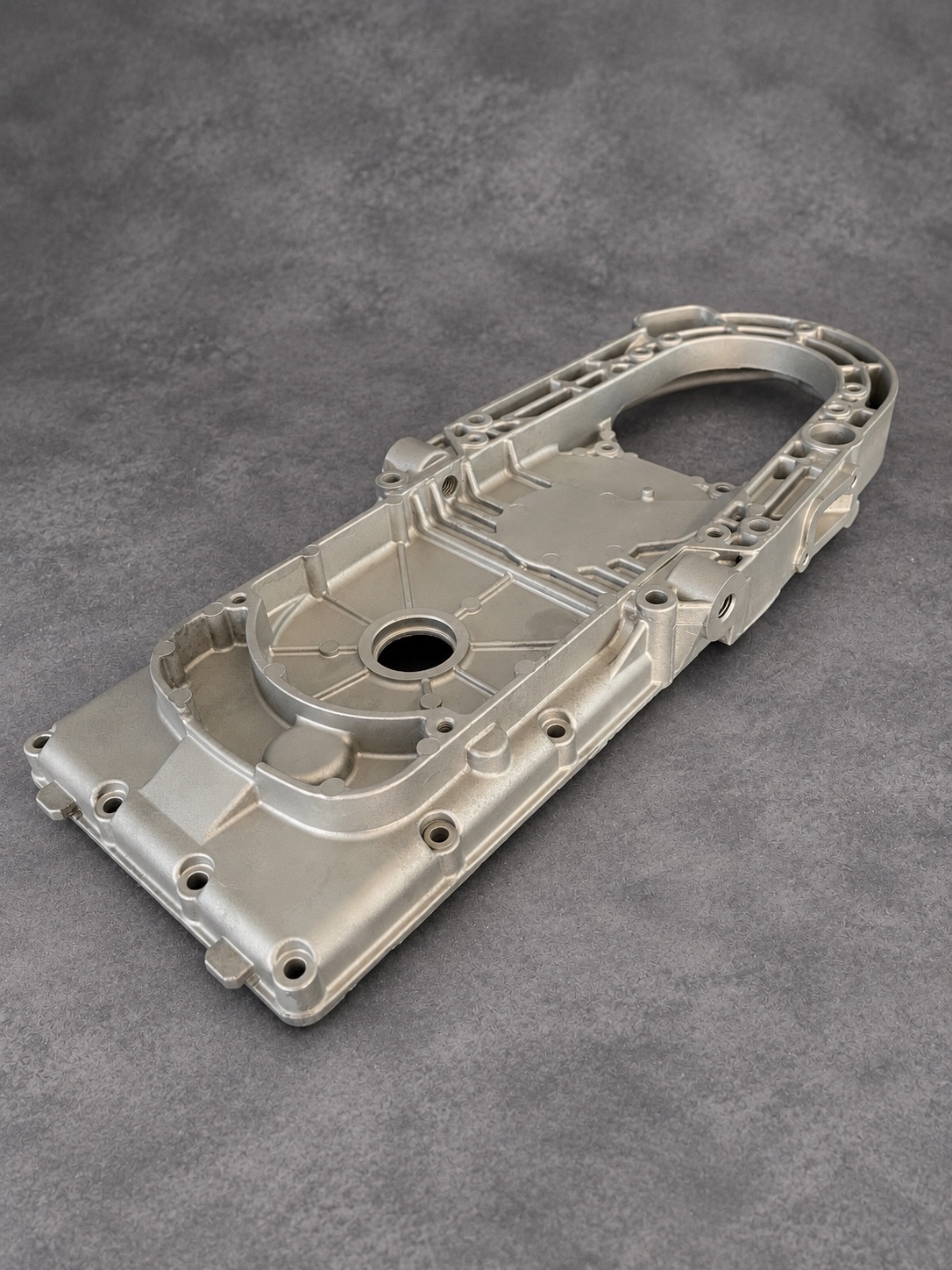 Vapour-blasted elongated alloy casing showing internal ribs, bearing openings and mounting holes
