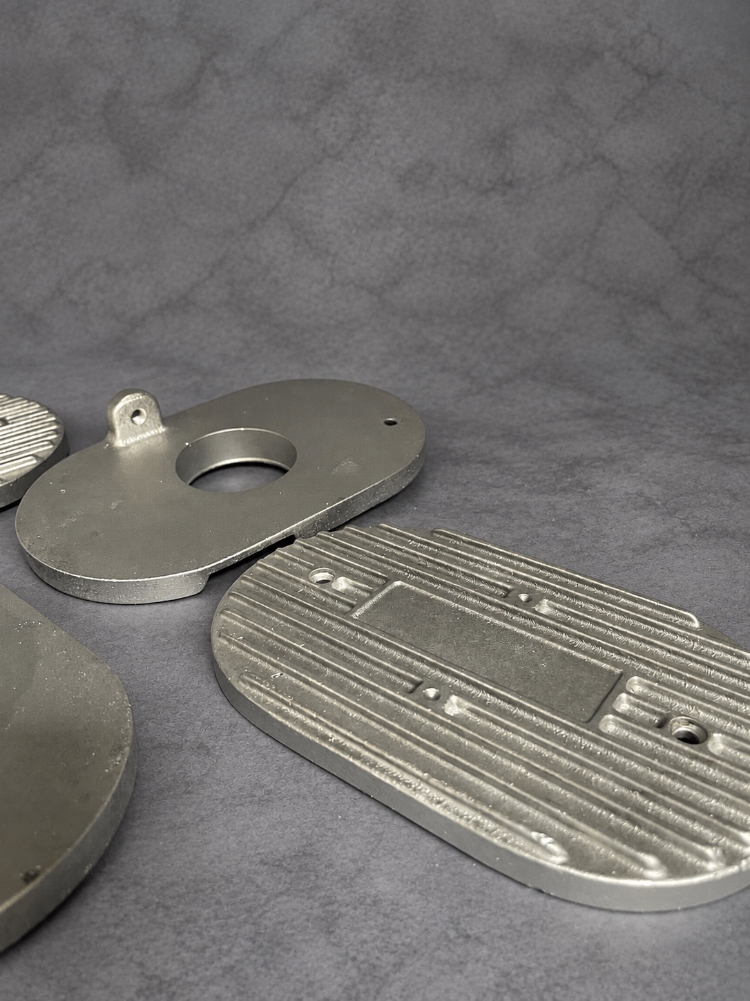 Angled view of vapour-blasted cast cover and mounting plates
