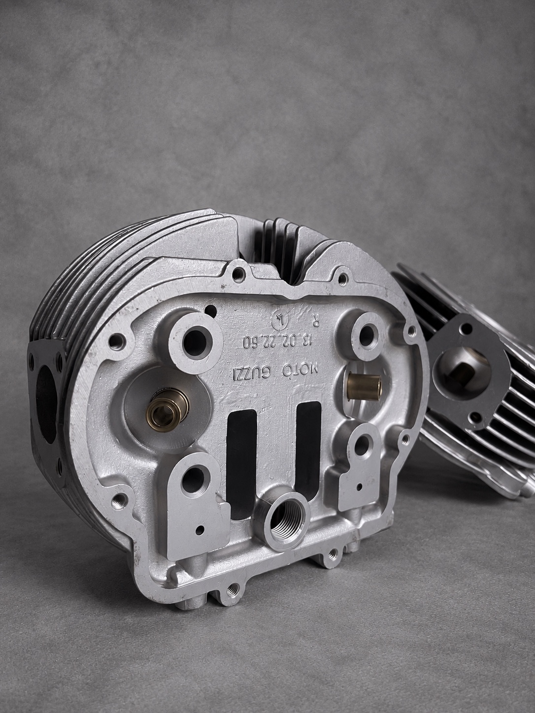 Vapour-blasted Moto Guzzi cylinder head showing casting marks, threaded holes and valve guides