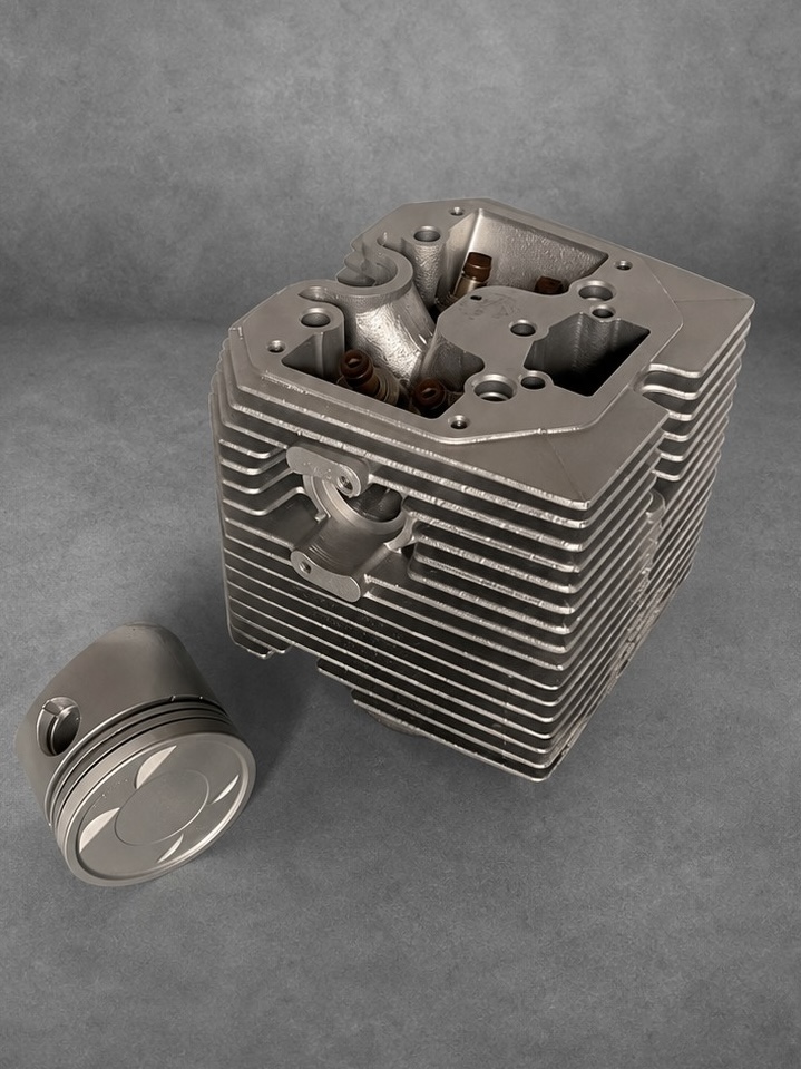 Vapour-blasted cylinder and head assembly with a piston on a textured grey surface